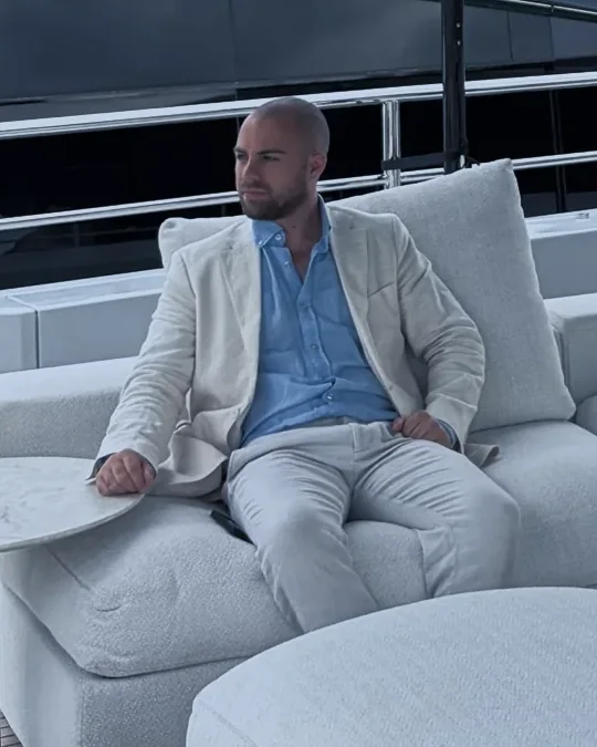 Jovan, seated on the deck of a yacht