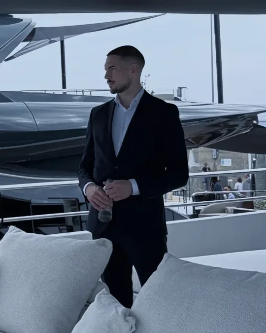 Nik, standing on the deck of a yacht